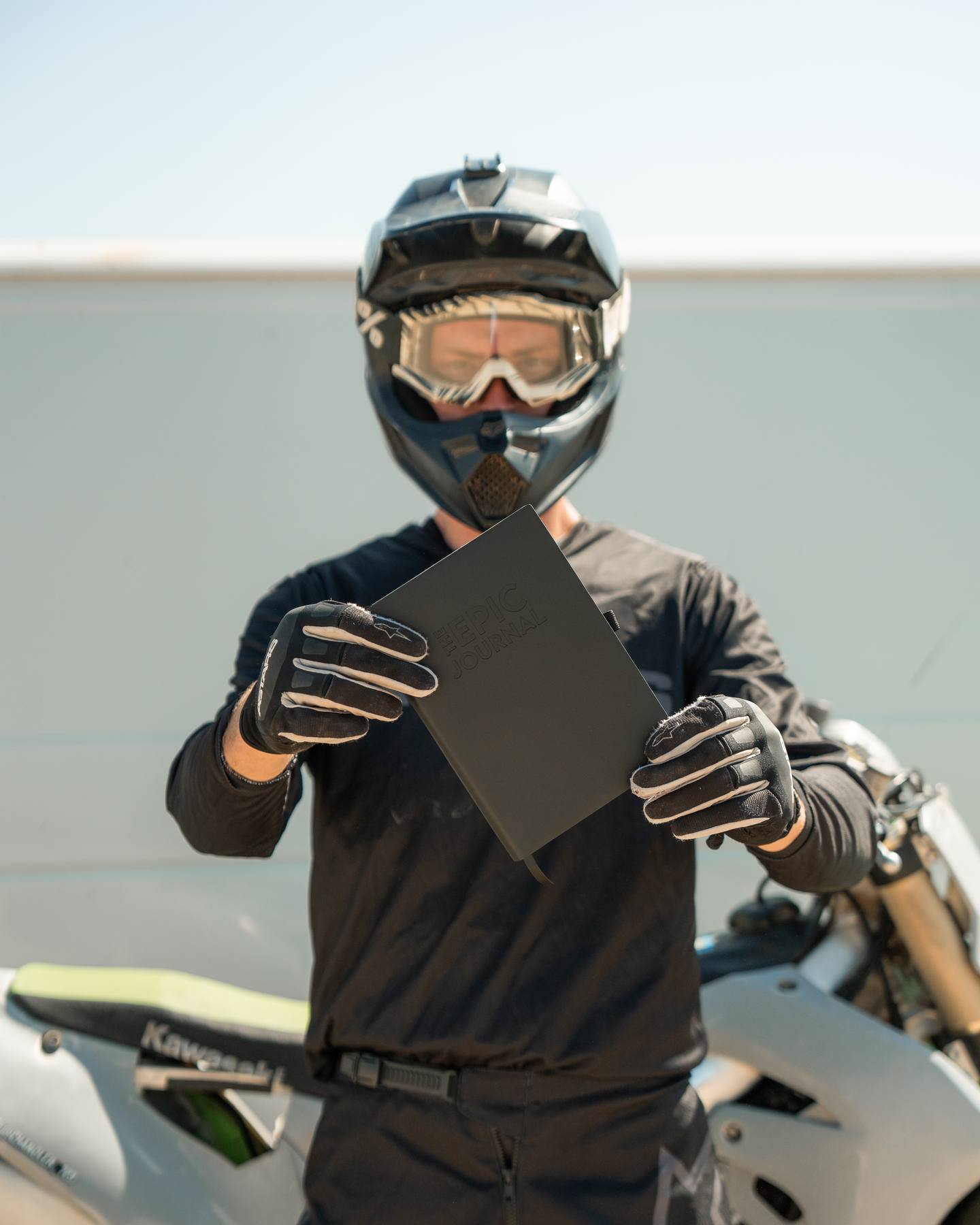 Motocross rider holding The Epic Journal